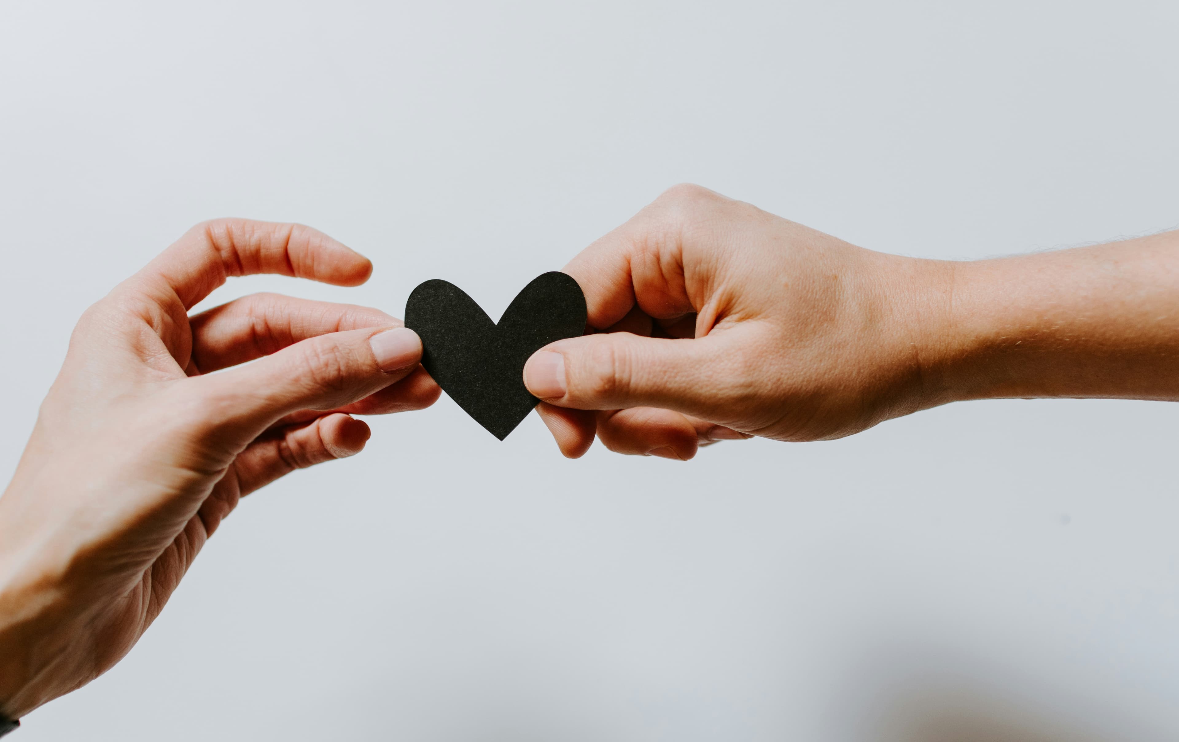 hands holding a paper heart